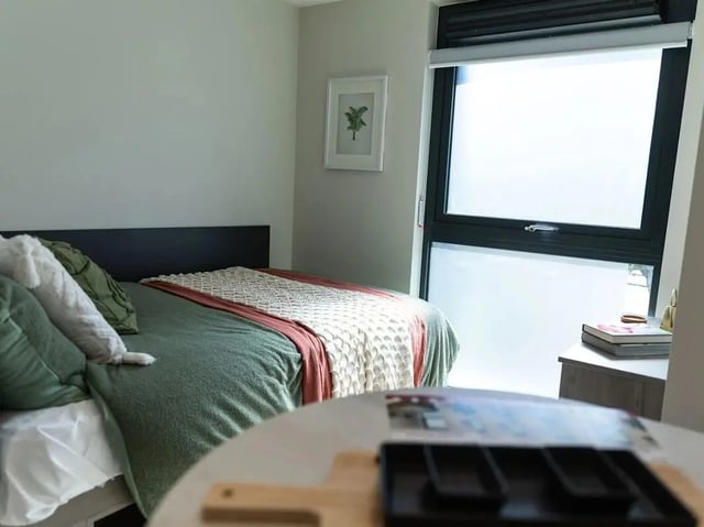 Bed with green bedding and pillows bedroom at Stanley Studios - Portsmouth in Portsmouth Student Accommodation