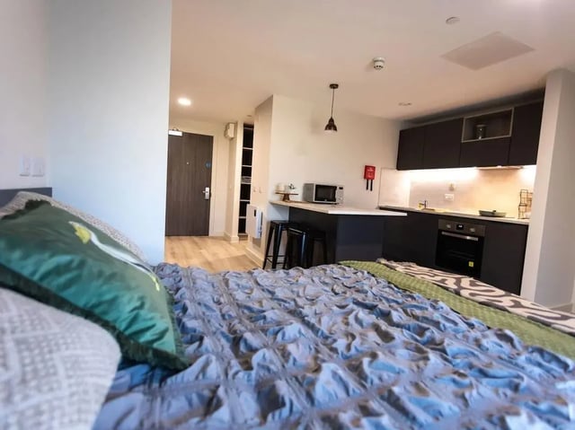 Bed kitchen cabinets microwave oven and stools studio apartment at Stanley Studios - Portsmouth in Portsmouth Student Accommodation