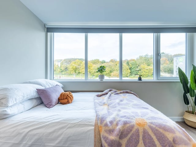 Bed with purple pillow and patterned blanket bedroom at Stanley Studios - Dundee in Dundee Student Accommodation