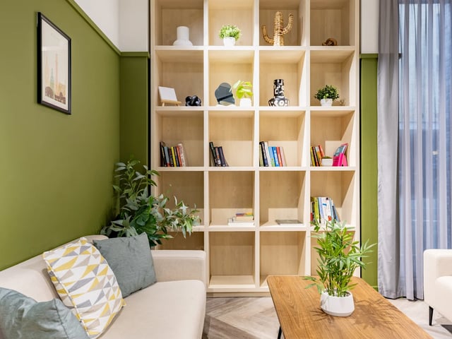 Sofa bookshelf with plants and framed art living room at Stanley Studios - Dundee in Dundee Student Accommodation