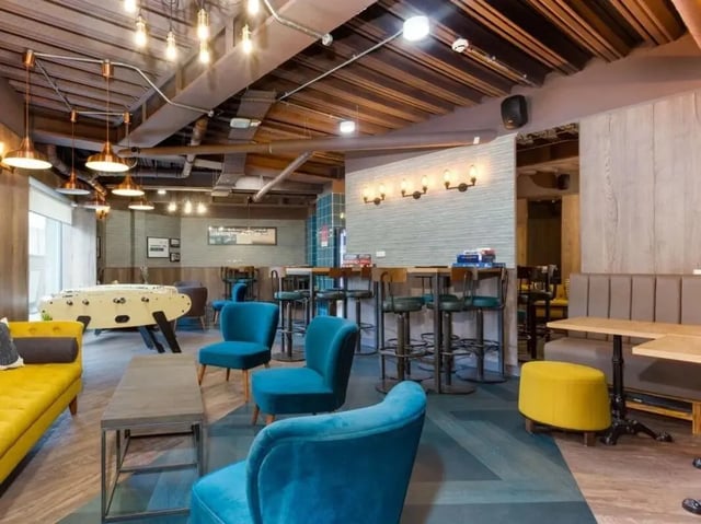 Foosball table couches chairs bar stools communal area at Woodside House in Glasgow Student Accommodation