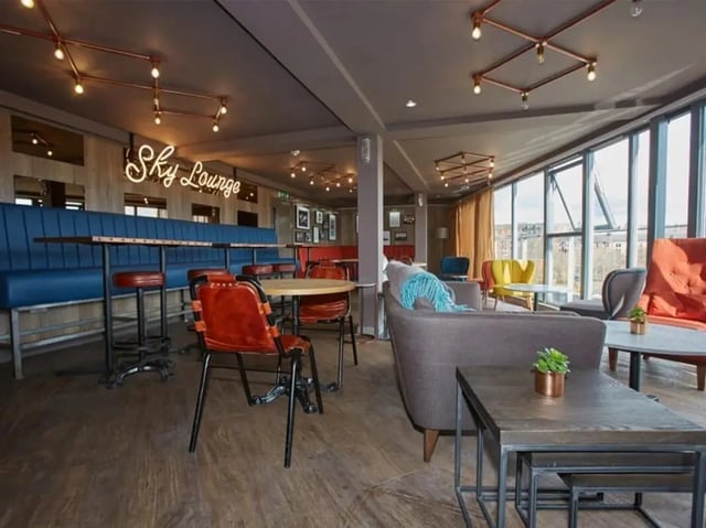 Sky Lounge neon sign sofas tables chairs lounge area at Woodside House in Glasgow Student Accommodation