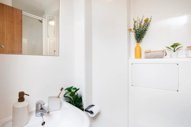 Sink soap dispenser toothbrush shower mirror bathroom at Purbeck House in Bournemouth Student Accommodation