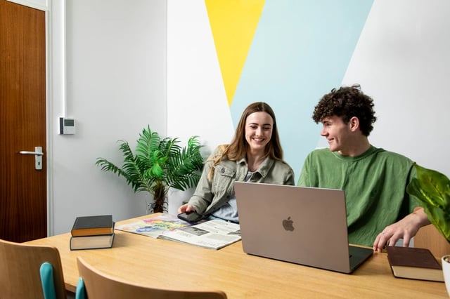 Students at desk with laptop books plants study area at Purbeck House in Bournemouth Student Accommodation