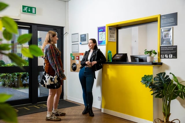 Two students at reception desk exterior at Purbeck House in Bournemouth Student Accommodation