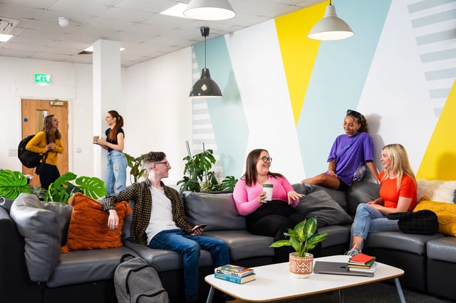 Students relaxing on sofa in lounge area living room at Purbeck House in Bournemouth Student Accommodation