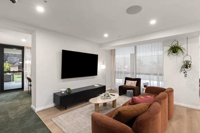 Sofa TV coffee table chair plants living room at UKO Parramatta Central in Sydney Student Accommodation