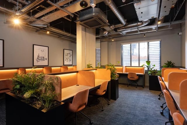 Study desks with orange chairs plants study area at Hayloft Point in London Student Accommodation