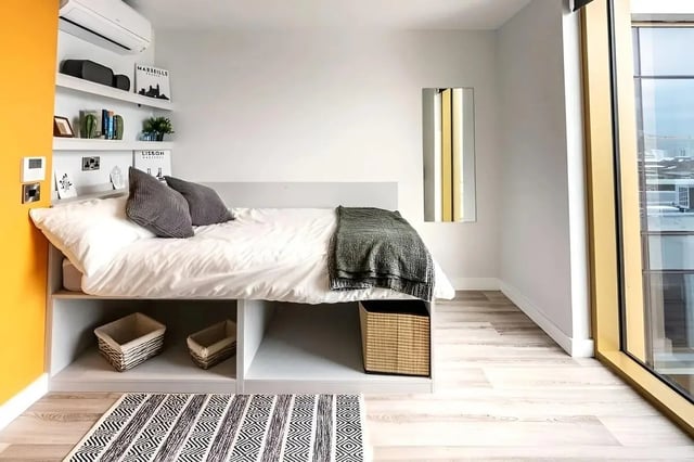 Bed with storage baskets and patterned rug bedroom at 123 York Street in Belfast Student Accommodation