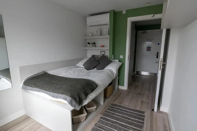 Bed with grey throw pillows and baskets bedroom at 123 York Street in Belfast Student Accommodation