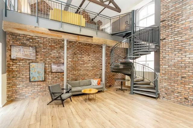 Sofa chairs coffee table spiral staircase loft living room at Sheffield 3 in Sheffield Student Accommodation