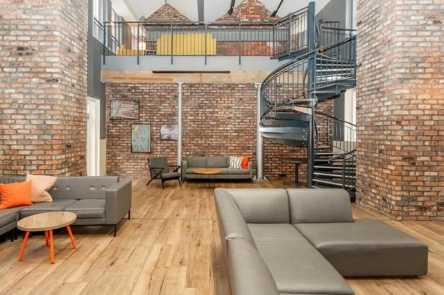 Grey sofas spiral staircase brick walls living room at Sheffield 3 in Sheffield Student Accommodation