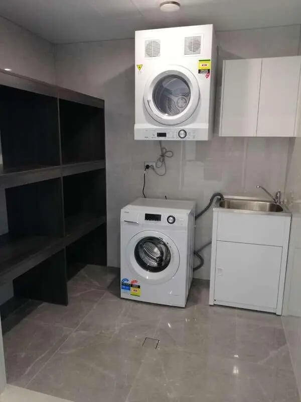 Washer dryer sink and shelves laundry area at Belong Macquarie in Sydney Student Accommodation
