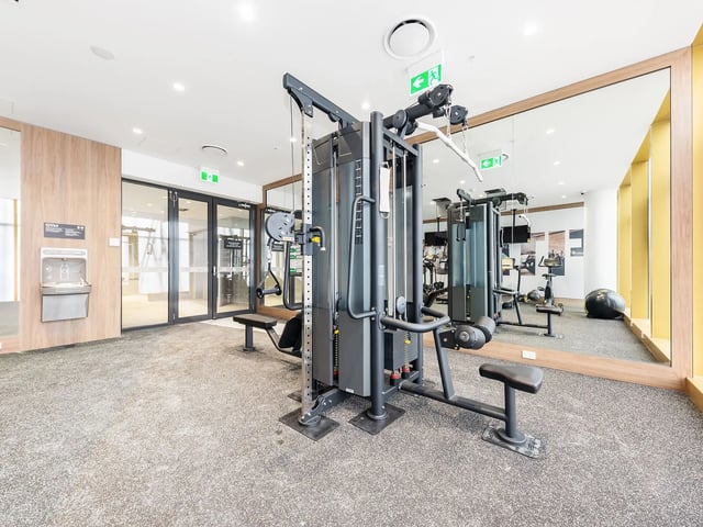 Gym with multi-station machine exercise bike and weights room at Belong Macquarie in Sydney Student Accommodation