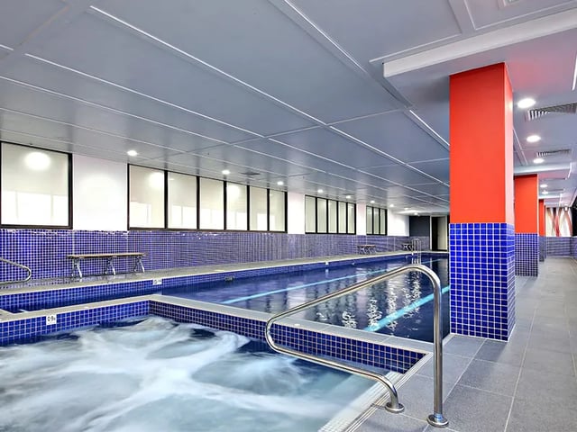 Indoor swimming pool with jacuzzi and benches swimming pool at Belong Zetland in Sydney Student Accommodation