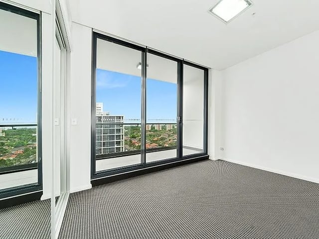 Large sliding glass doors offer city views. Living room at Belong Zetland in Sydney Student Accommodation