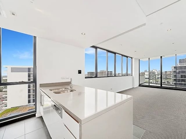 Kitchen counter sink cabinets window balcony living room at Belong Zetland in Sydney Student Accommodation