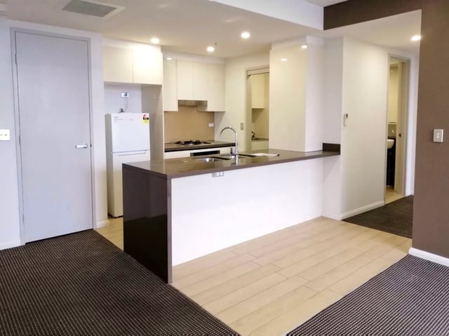 Fridge stove sink island and cabinets kitchen interior at Belong Zetland in Sydney Student Accommodation
