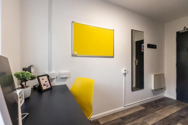 Desk plant clock yellow chair whiteboard mirror study area at Woodhouse Flats in Leeds Student Accommodation