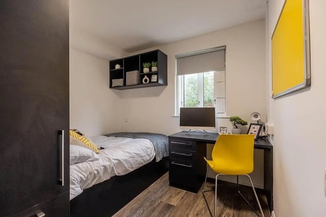 Bed desk shelves and yellow chair bedroom at Woodhouse Flats in Leeds Student Accommodation