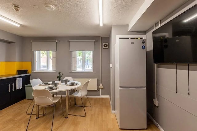 Table chairs fridge and television kitchen at Woodhouse Flats in Leeds Student Accommodation