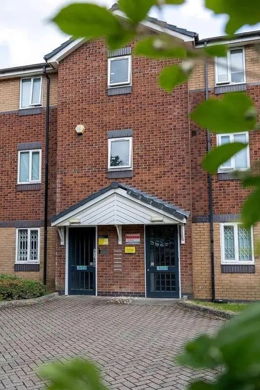 Brick building entrance with two doors and windows exterior at Woodhouse Flats in Leeds Student Accommodation