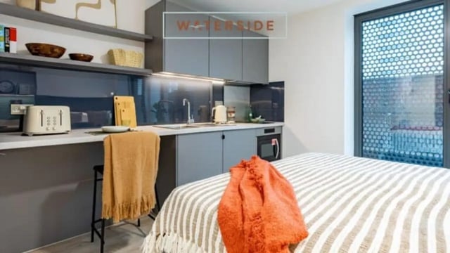 Studio apartment with bed kitchenette and chair interior at Waterside in Bristol Student Accommodation