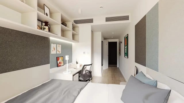 Bed desk shelving and doorway bedroom at Signal House in London Student Accommodation