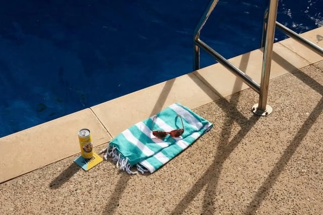 Towel sunglasses can by pool exterior at Campus Melbourne in Melbourne Student Accommodation