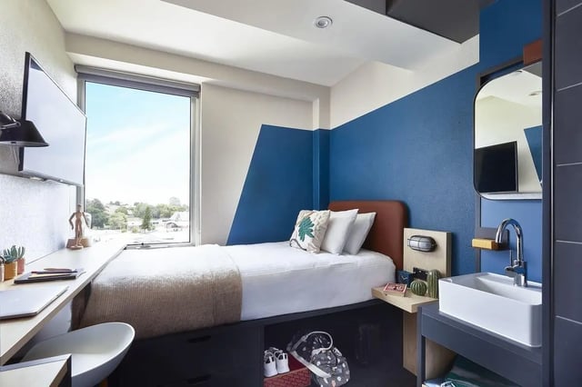 Bed desk TV window and sink bedroom at Campus Melbourne in Melbourne Student Accommodation