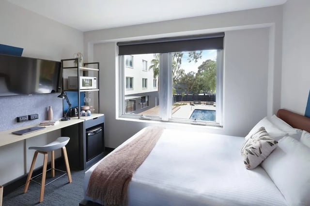 Bed desk microwave mini-fridge with pool view Bedroom at Campus Melbourne in Melbourne Student Accommodation