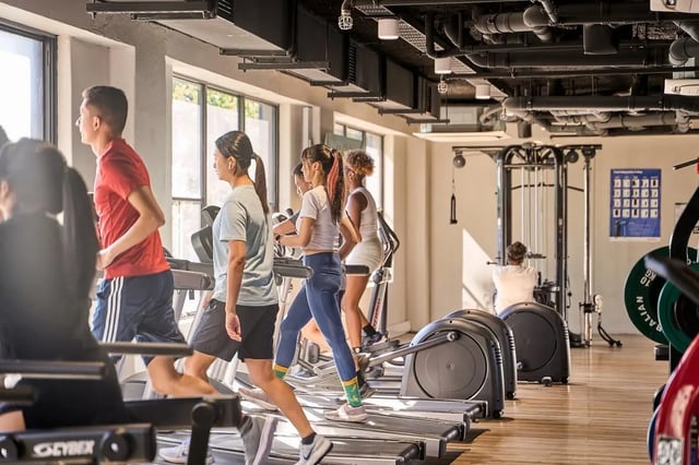 Students exercising on treadmills and elliptical machines gym area at Campus Melbourne in Melbourne Student Accommodation