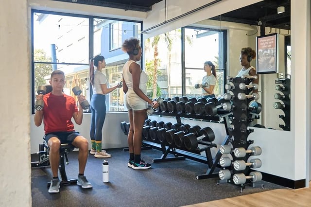 Students lifting weights and dumbbells gym at Campus Melbourne in Melbourne Student Accommodation