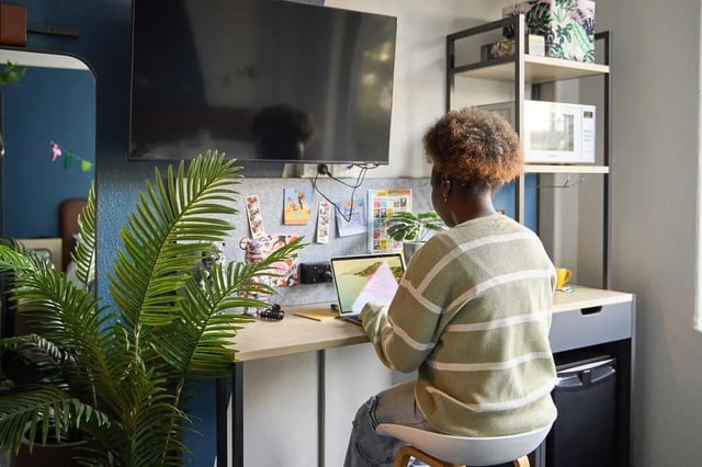 Student studies at desk with laptop and TV Study area at Campus Melbourne in Melbourne Student Accommodation