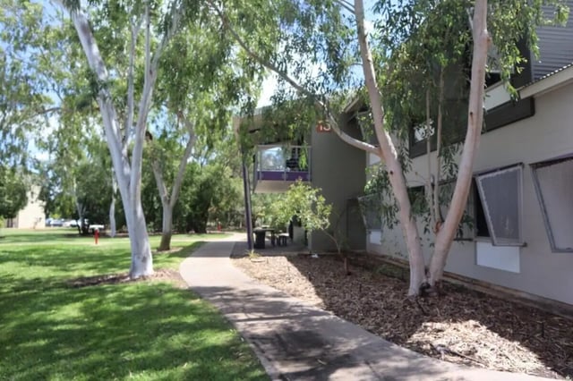 Building with pathway trees and grass exterior at CDU Village Casuarina in Darwin Student Accommodation