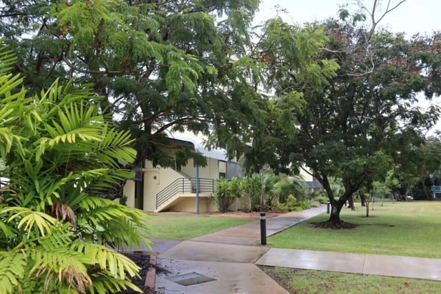 Campus building with stairs surrounded by trees exterior at CDU Village Casuarina in Darwin Student Accommodation