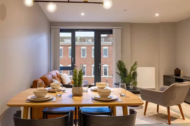 Dining table with place settings and sofa living room at The Port On The Square in Bristol Student Accommodation