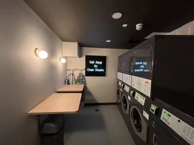 Laundry machines ironing boards and tables laundry room at The Port On The Square in Bristol Student Accommodation