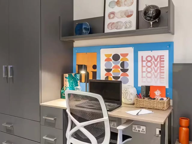 Desk with laptop chair art and storage study area at Grosvenor House in London Student Accommodation