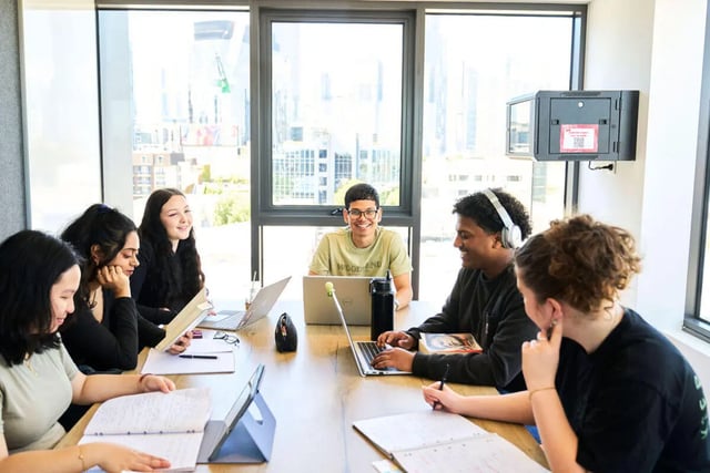 Students work and study at a communal table living room at UniLodge Royal Melbourne in Melbourne Student Accommodation