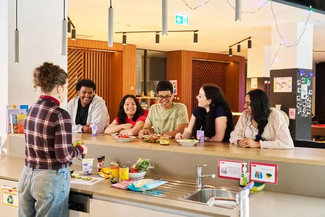 Students chatting at a kitchen counter communal area at UniLodge Royal Melbourne in Melbourne Student Accommodation