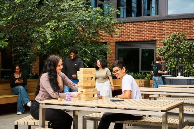 Students playing giant Jenga at outdoor tables playing area at UniLodge Royal Melbourne in Melbourne Student Accommodation