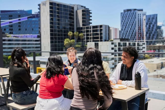 Students eating on rooftop balcony with city view exterior at UniLodge Royal Melbourne in Melbourne Student Accommodation