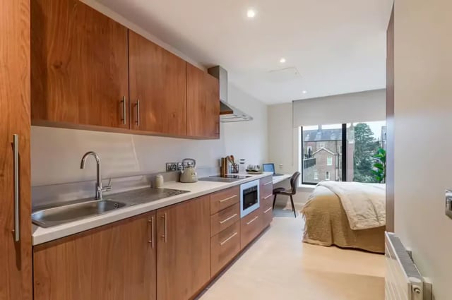 Wooden cabinets sink oven and bed studio apartment at Ryan Hall in Belfast Student Accommodation