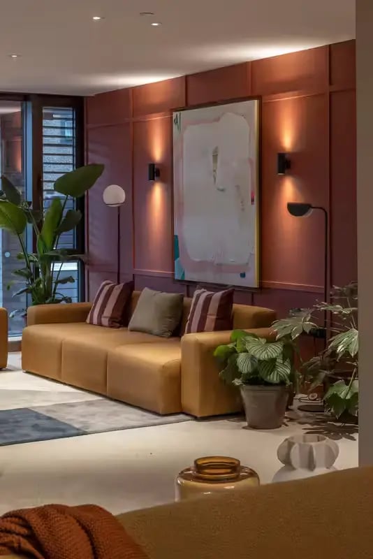 Tan sofa with striped pillows plants art living room at The Pepper Mill in Edinburgh Student Accommodation