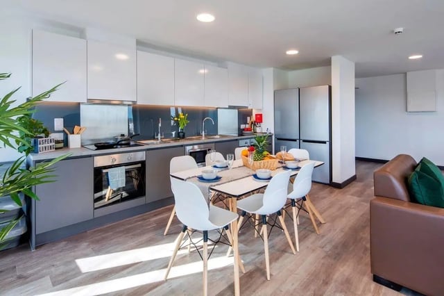 Modern kitchen with dining table and brown sofa. Kitchen at Aspen Dublin in Dublin Student Accommodation