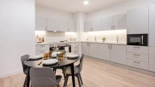 Dining table with chairs and modern kitchen Image Type at St Gabriels in Manchester Student Accommodation