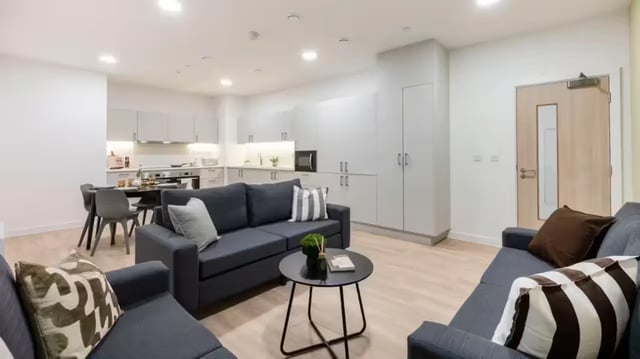 Sofa dining table kitchen cabinets door living room at St Gabriels in Manchester Student Accommodation