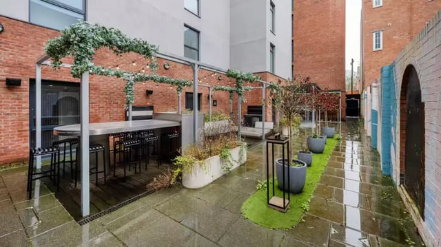 Outdoor seating area with bar and plants exterior at The Aspen in Leicester Student Accommodation