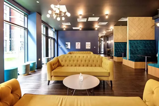 Yellow sofas blue booths and round tables living room at Howard Gardens in Cardiff Student Accommodation